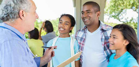 A CommUnify staff member sitting down with a family